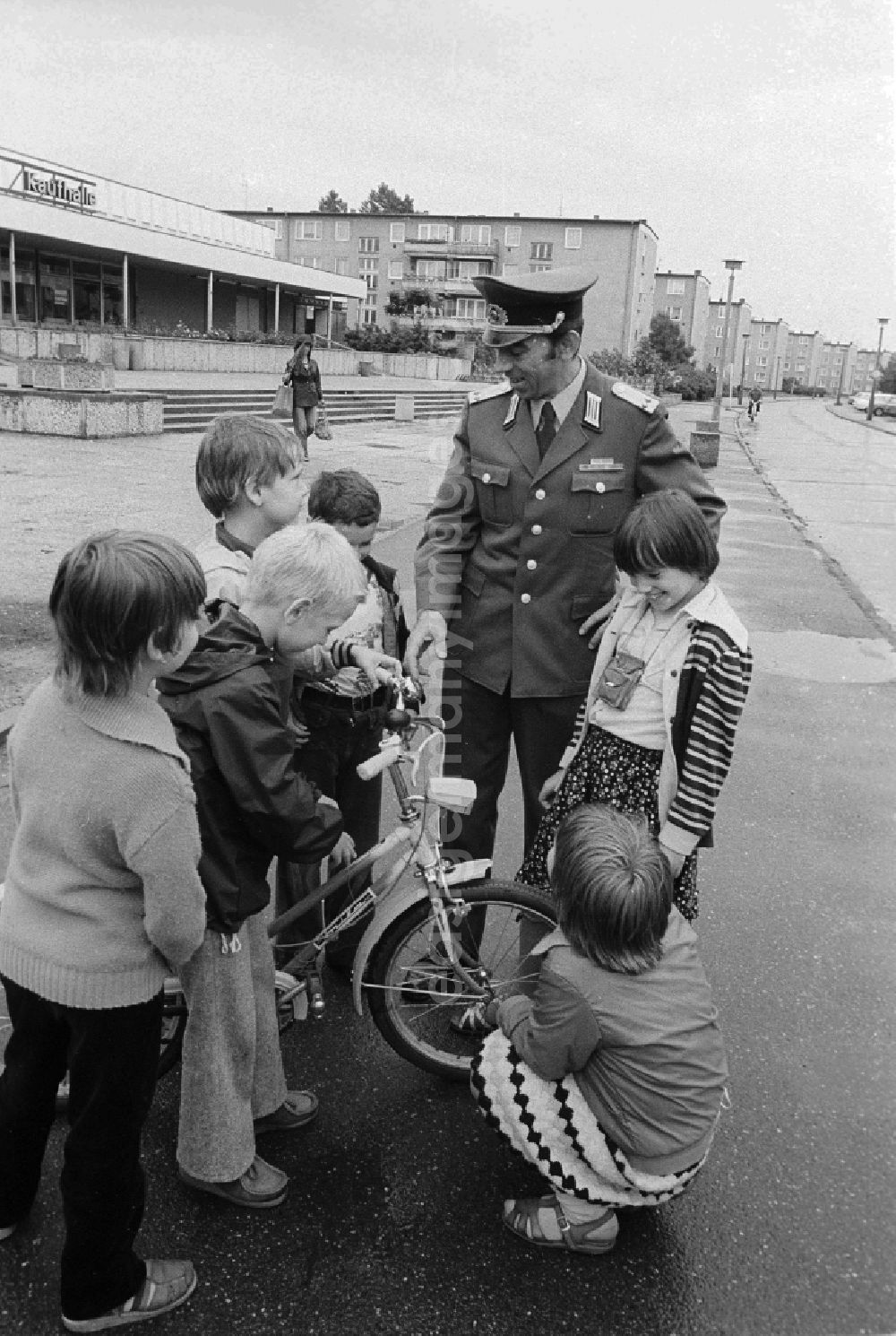 GDR photo archive: Berlin - A member of the People's Police / of segment authorised representative (ABV) with the road safety education in Berlin, the former capital of the GDR, German democratic republic. Here he controls the traffic suitability of a bicycle of the children