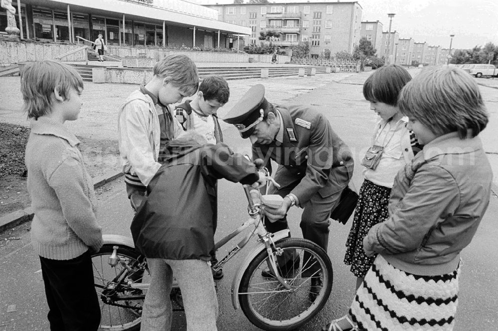 Berlin: A member of the People's Police / of segment authorised representative (ABV) with the road safety education in Berlin, the former capital of the GDR, German democratic republic. Here he controls the traffic suitability of a bicycle of the children
