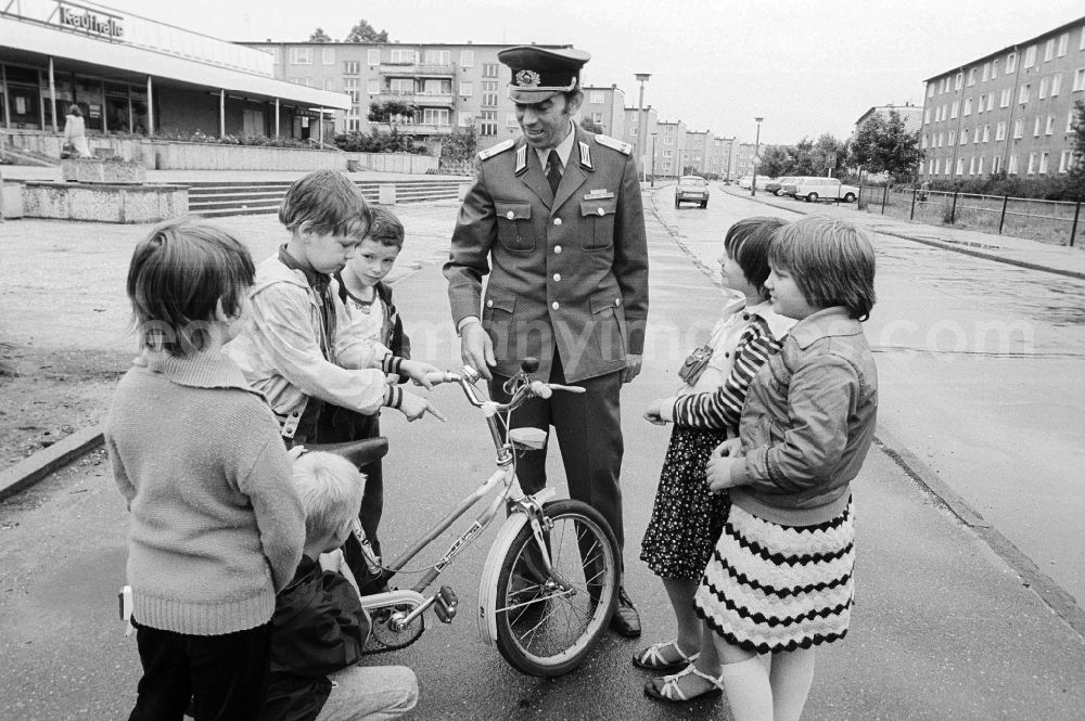 GDR photo archive: Berlin - A member of the People's Police / of segment authorised representative (ABV) with the road safety education in Berlin, the former capital of the GDR, German democratic republic. Here he controls the traffic suitability of a bicycle of the children