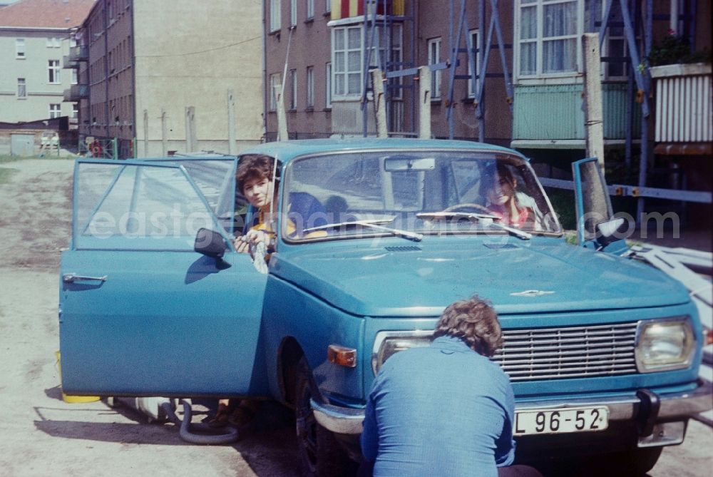 GDR photo archive: Neustrelitz - A family cleans their blue Wartburg 353 in Neustrelitz in Mecklenburg-Vorpommern on the territory of the former GDR, German Democratic Republic
