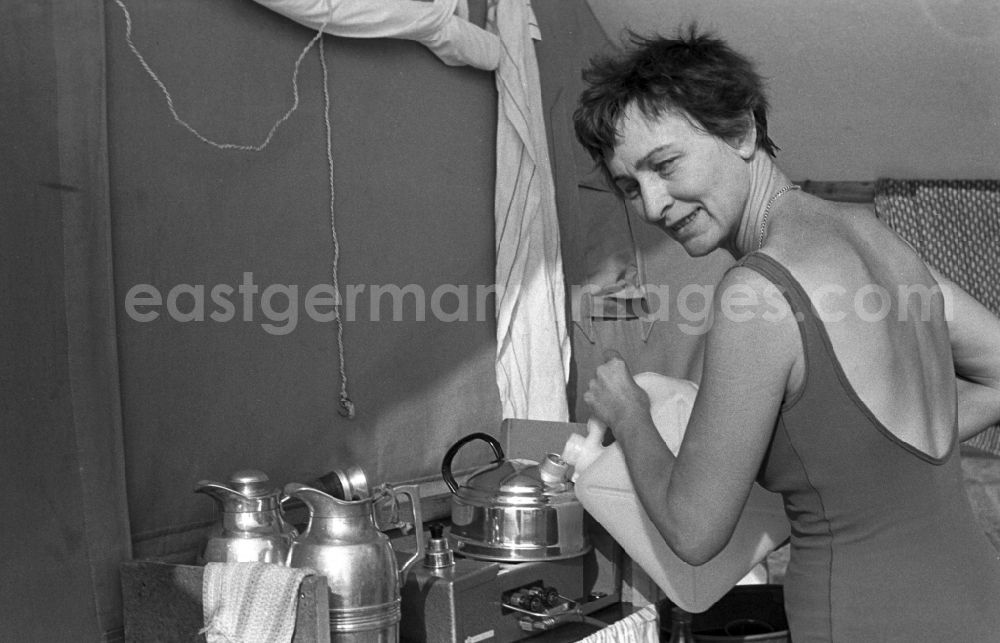 GDR photo archive: Neuruppin OT Stendenitz - A woman while cooking on a Caminggaskocher in Brandenburg. Family camping holidays at Rottstielfließ on Tornowsee