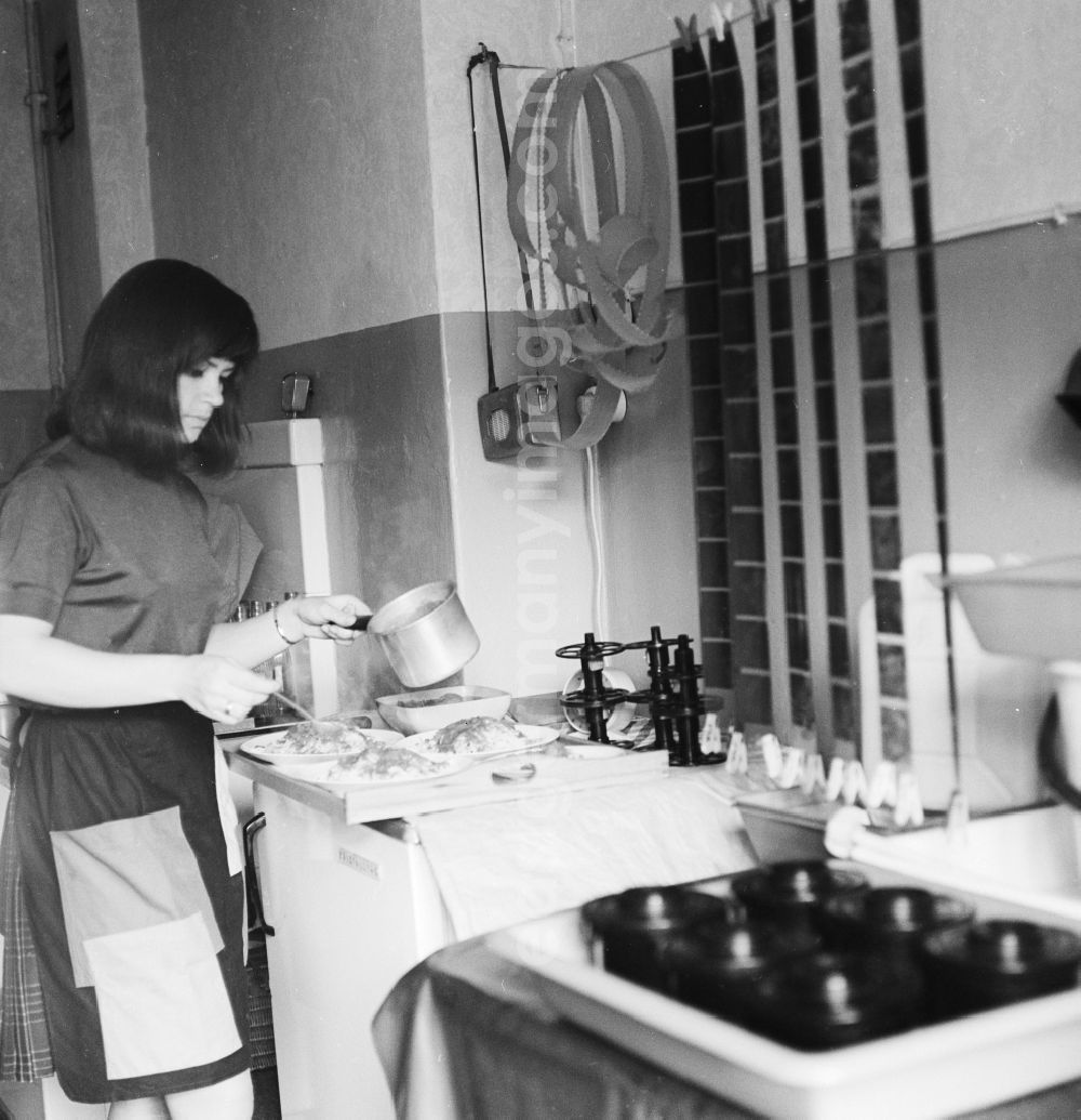 GDR picture archive: Berlin - A woman prepares food while suspended in the kitchen Films drying in Berlin, the former capital of the GDR, the German Democratic Republic