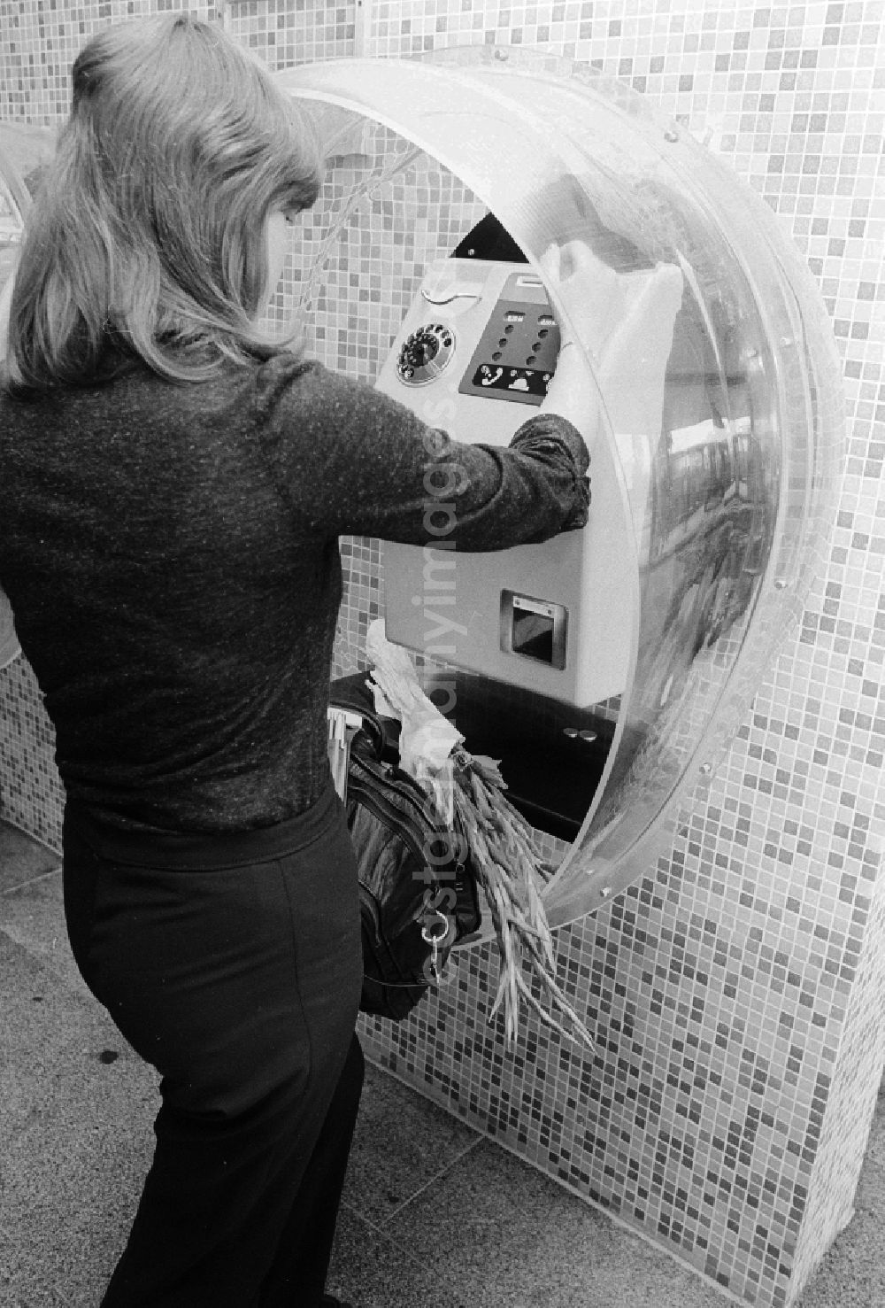 Schönefeld: A woman calls up a pay phone in the railway station airport Berlin-Schoenefeld in Schoenefeld in the federal state Brandenburg in the area of the former GDR, German democratic republic