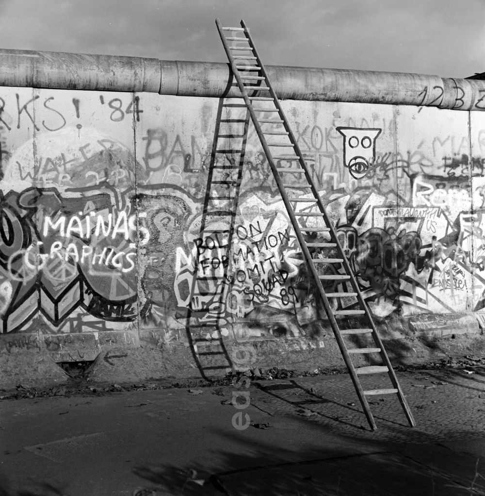 GDR photo archive: Berlin - Mitte - A wooden ladder leaning against the wall crown of the Berlin Wall in Berlin - Mitte