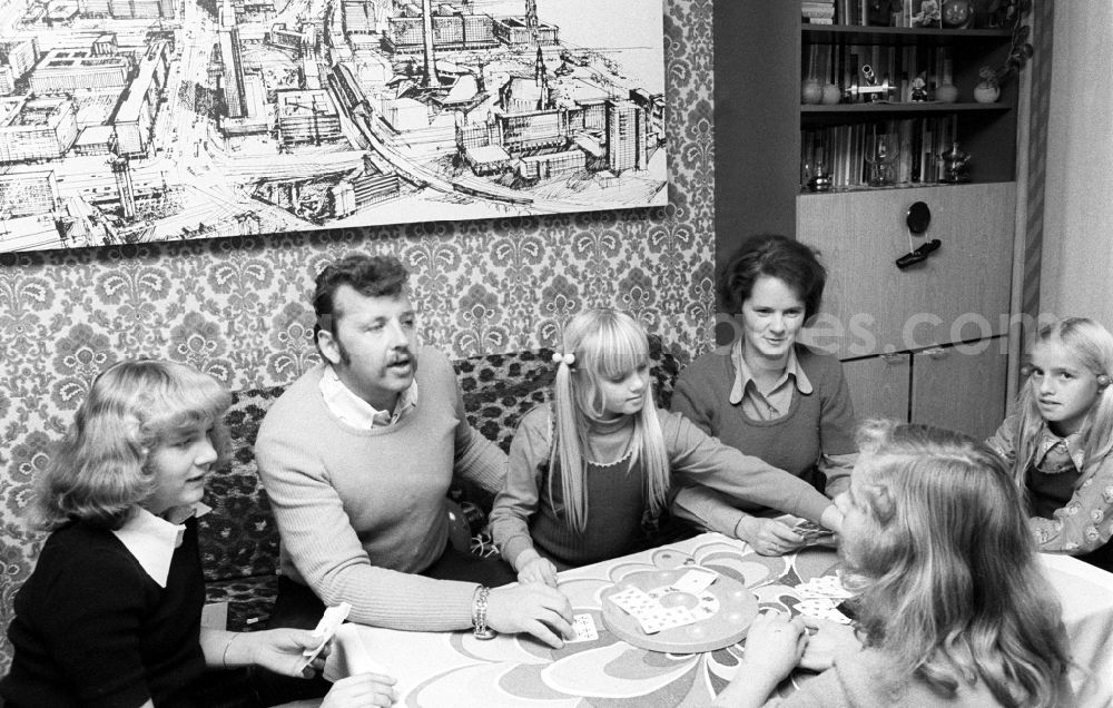 GDR photo archive: Berlin - A young family playing cards in the living room in Berlin