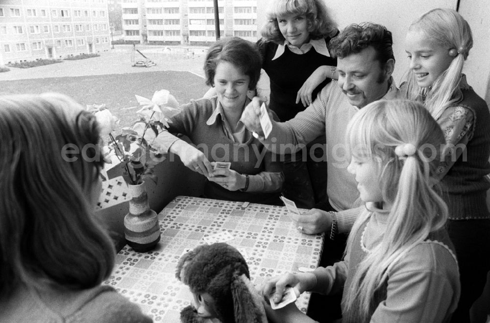GDR photo archive: Berlin - A young family playing cards on the balcony in Berlin