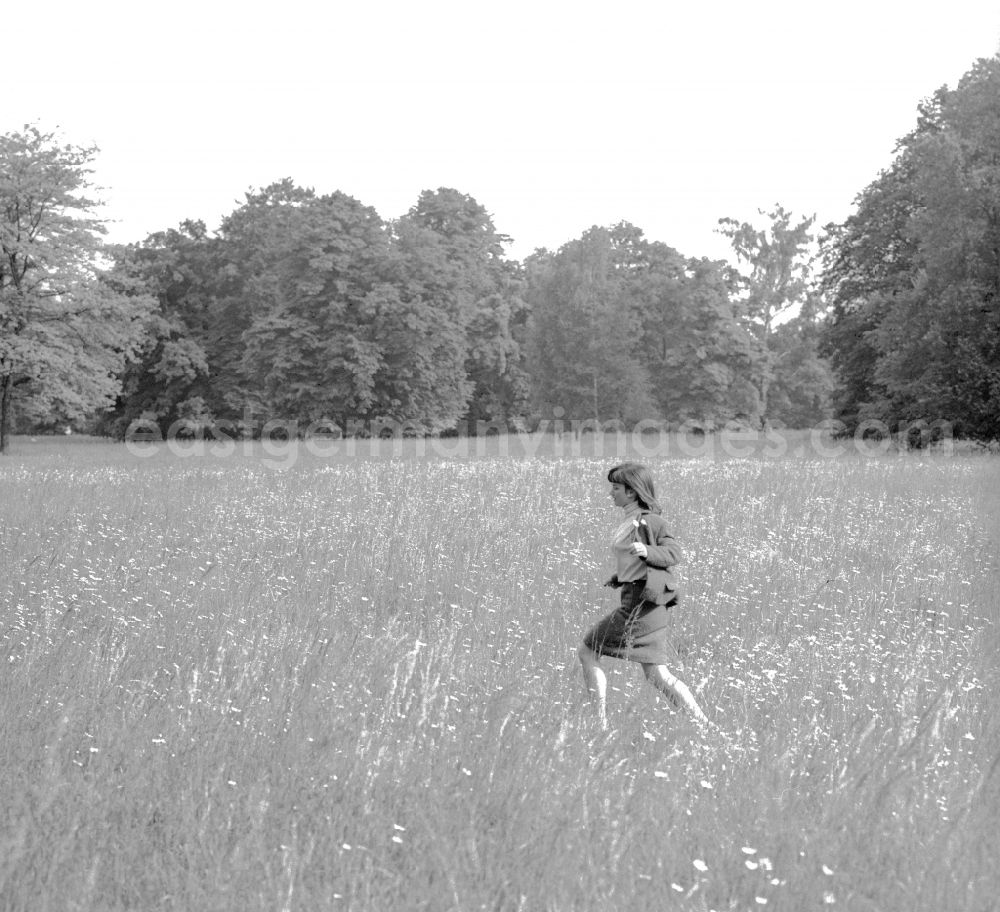 Potsdam: A young woman runs across a meadow in Potsdam in the federal state of Brandenburg on the territory of the former GDR, the German Democratic Republic