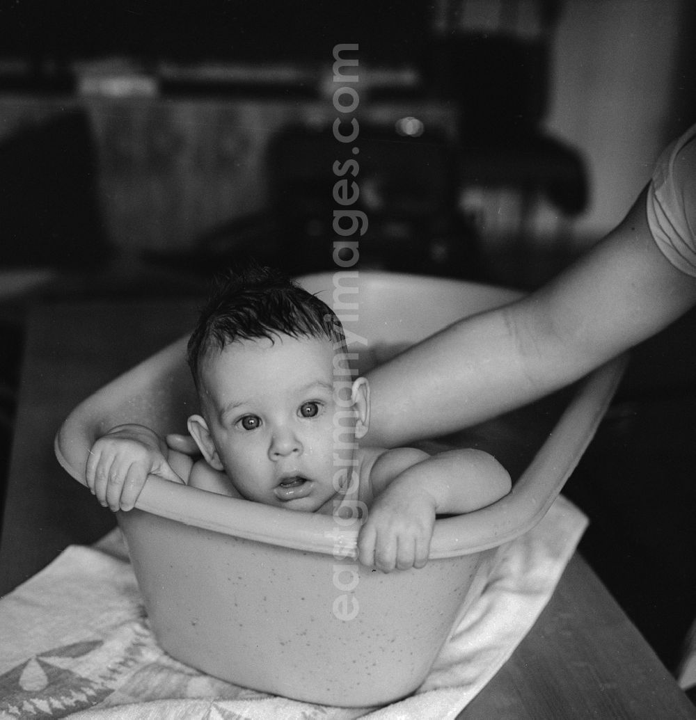 GDR photo archive: Berlin - A mother bathes her baby in a plastic tub in Berlin, the former capital of the GDR, the German Democratic Republic
