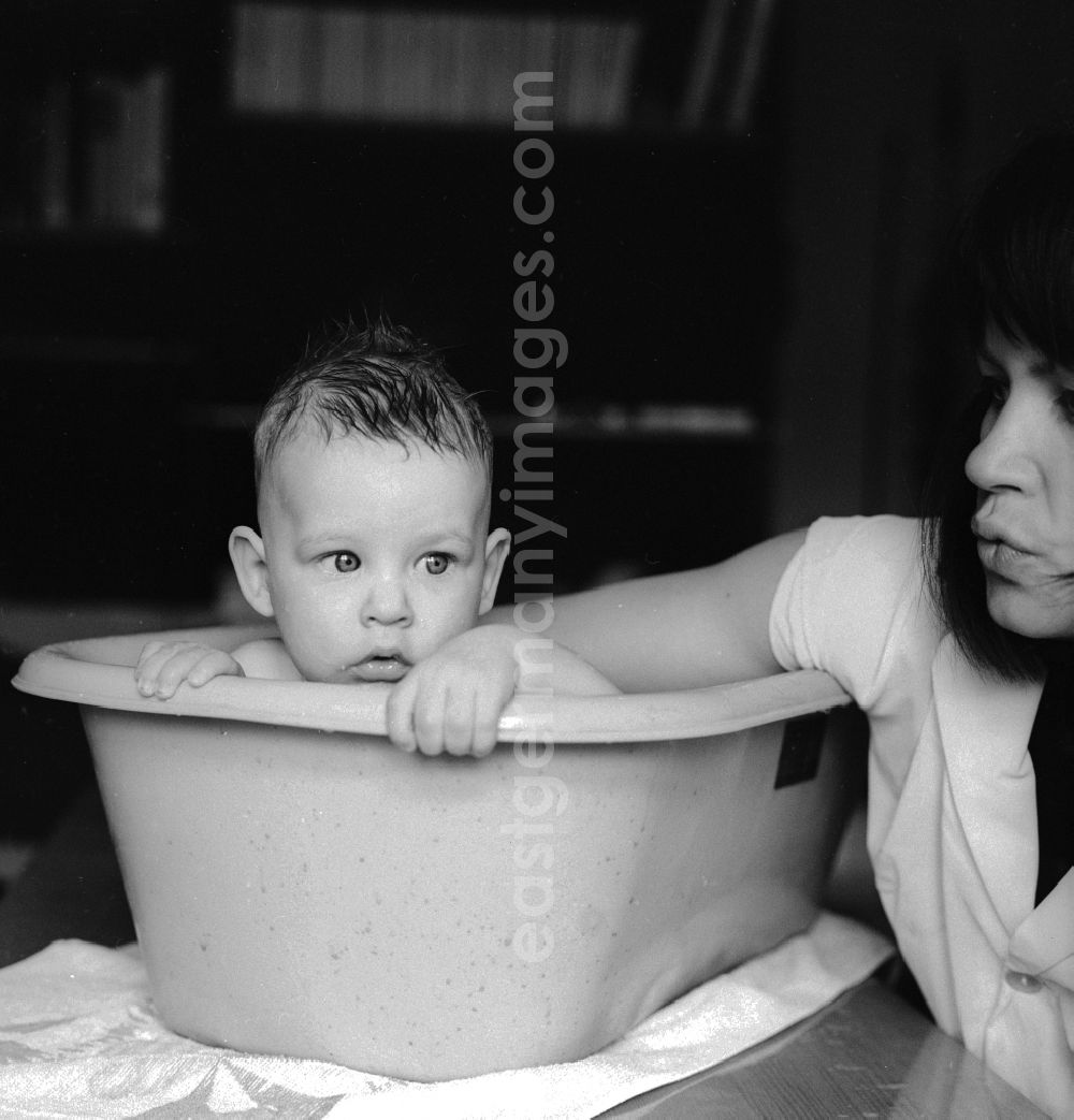 GDR image archive: Berlin - A mother bathes her baby in a plastic tub in Berlin, the former capital of the GDR, the German Democratic Republic
