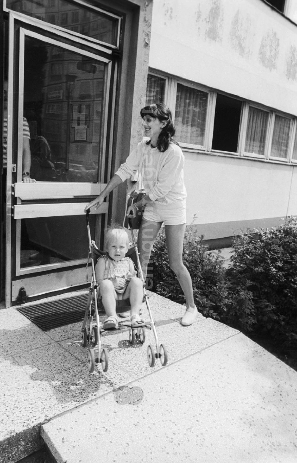 GDR photo archive: Berlin - A mother brings her child in the baby carriage in the cradle in Berlin, the former capital of the GDR, German democratic republic