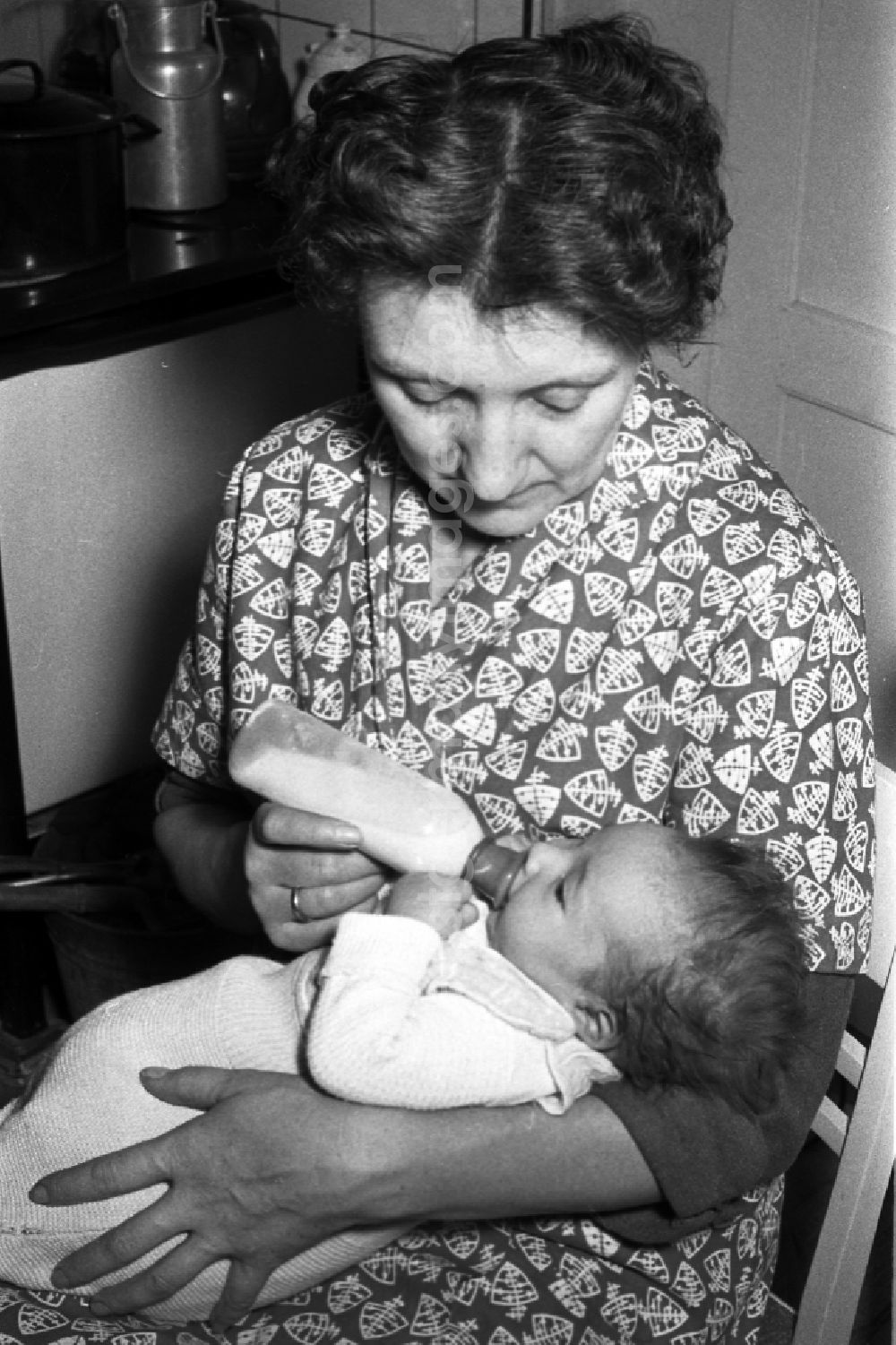 GDR picture archive: Merseburg - A mother gives to her baby the teat bottle in Merseburg in the federal state Saxony-Anhalt in the area of the former GDR, German democratic republic