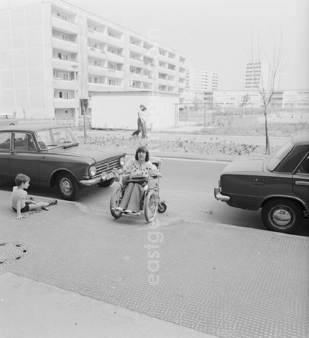GDR image archive: Berlin - A wheelchair user moves accessible on the street in Berlin-Marzahn