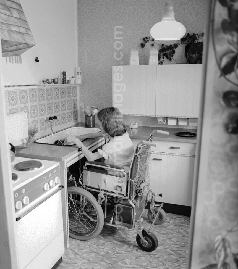 Berlin: A wheelchair user, wash in her wheelchair in the kitchen, at her home in Berlin