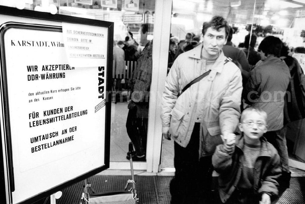 GDR image archive: Berlin - Mann mit Kind am Eingang von Karstadt / Kaufhaus in West-Berlin neben Schild mit der Aufschrift Wir akzeptieren DDR-Währung.