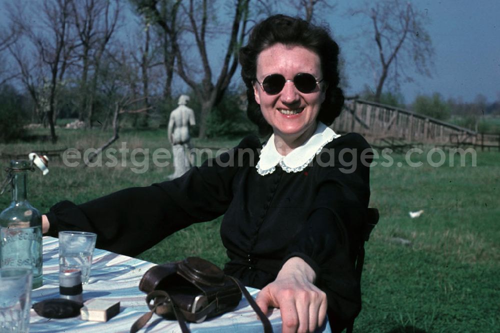 GDR image archive: Bad Godesberg - Frau mit Sonnenbrille sitzt im Park am Tisch und genießt die Frühlungssonne. Woman with sunglasses sitting in the park at a table and enjoys the bathe in the sun.
