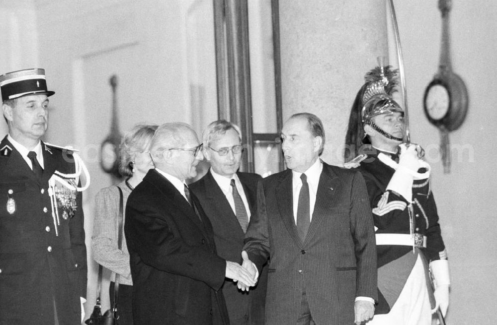 Paris: Erich Honecker, Vorsitzender des Staatsrates DDR, wird von Francois Mitterrand, Staatspräsident Frankreich, in Paris im Elysee-Palast empfangen und reichen sich die Hände. Im Hintergrund ein Leibgardist mit erhobenem Säbel.