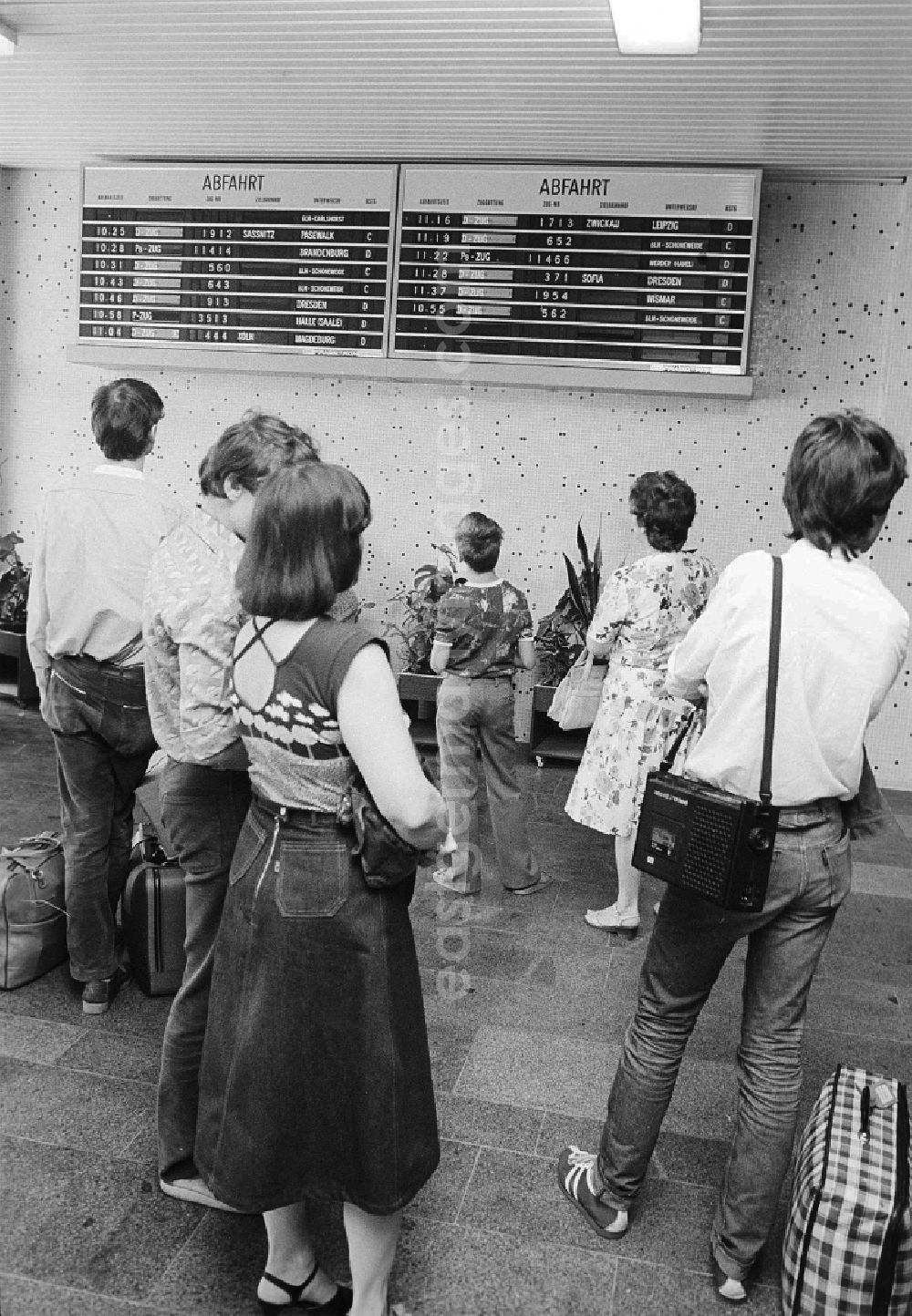Schönefeld: Passengers find out in the scoreboard about departure and arrival of the trains in the railway station airport Berlin-Schoenefeld in Schoenefeld in the federal state Brandenburg in the area of the former GDR, German democratic republic