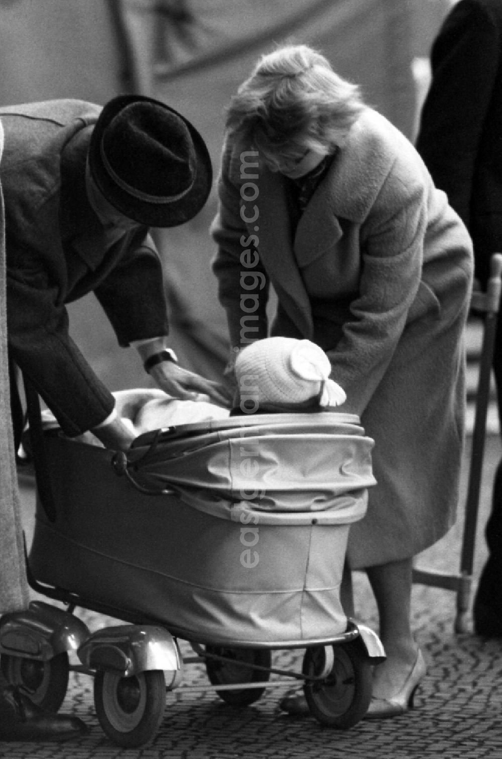 GDR picture archive: Berlin - Parents care for their child in a stroller in East Berlin in the territory of the former GDR, German Democratic Republic
