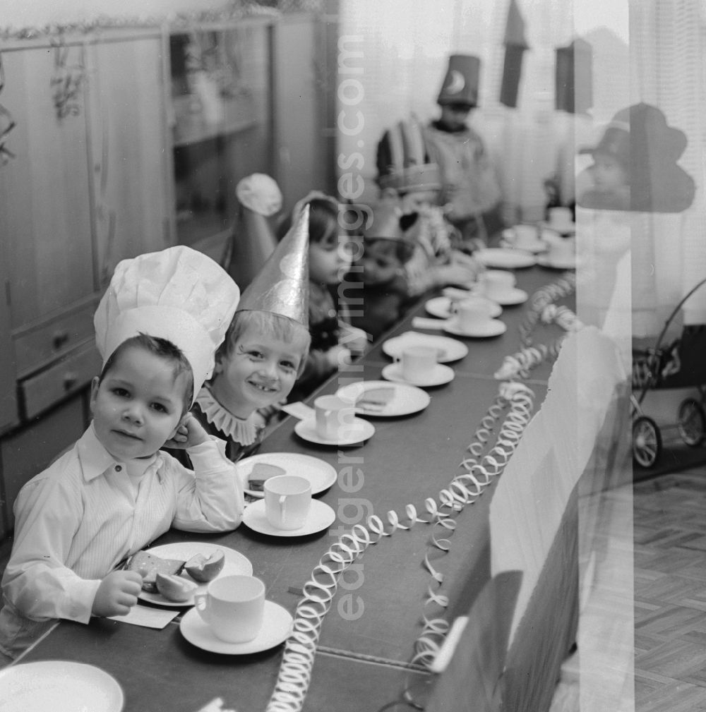 GDR photo archive: Berlin - Carnival in kindergarten in Berlin. The children sit on the decked Vesper panel