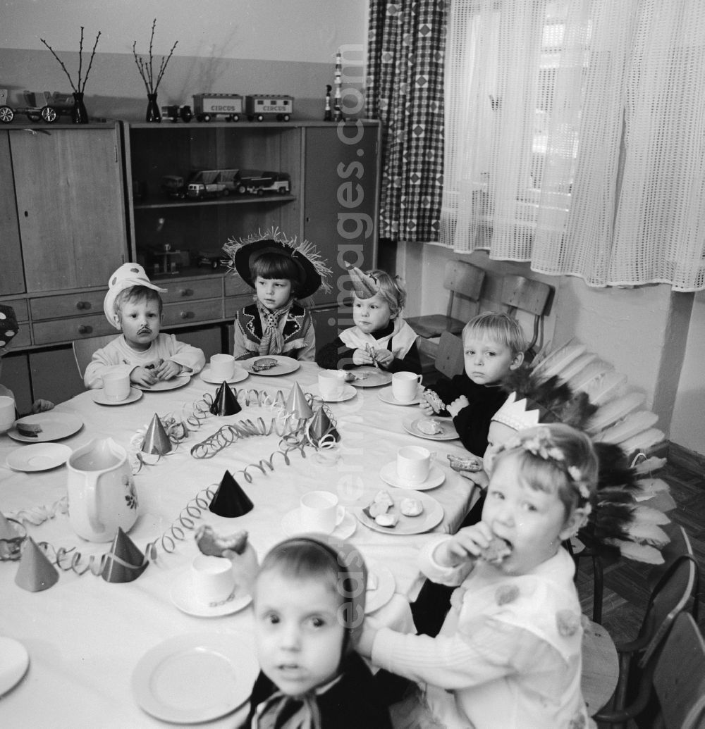 GDR image archive: Berlin - Carnival in kindergarten in Berlin. The clad children sit at the table decorated Vesper