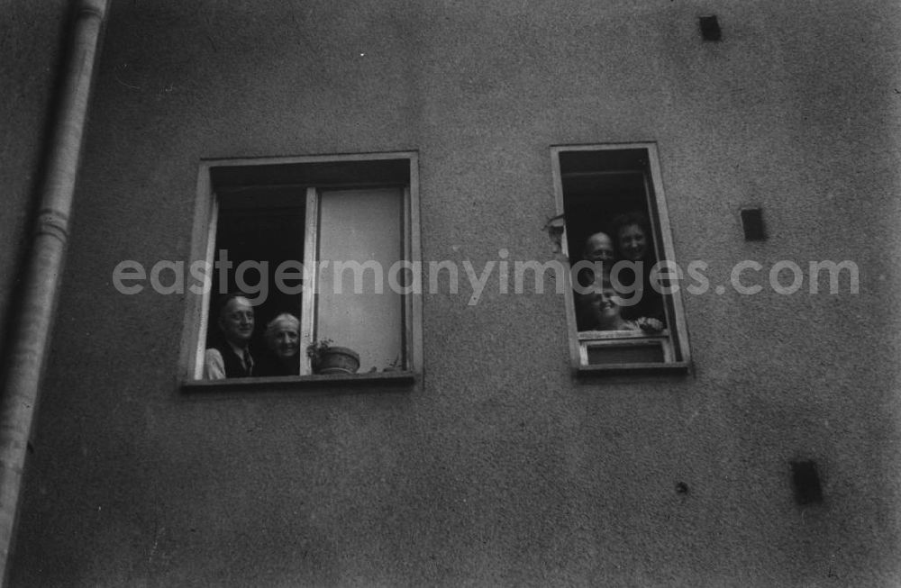 Merseburg: Anwohner eines Mehrfamilienhauses gucken aus dem Fenster. Residents of an apartment building look out of the window.