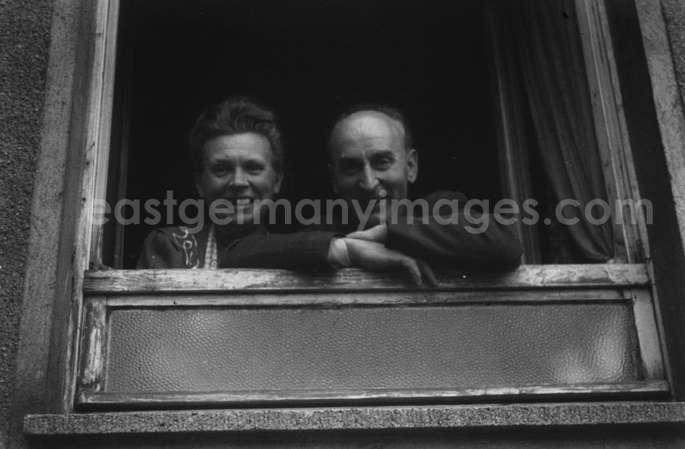 GDR picture archive: Merseburg - Anwohner eines Mehrfamilienhauses gucken aus dem Fenster. Residents of an apartment building look out of the window.