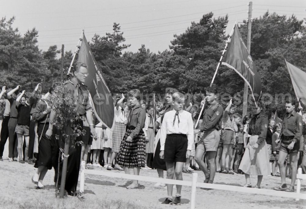 GDR picture archive: Prerow - Day Appell in summer camp with students and youth in FDJ uniform with flags and banners in the summer camp Kim Ir Sen of the pioneer organization Ernst Thalmann in Prerow in the state Mecklenburg-Western Pomerania on the territory of the former GDR, German Democratic Republic