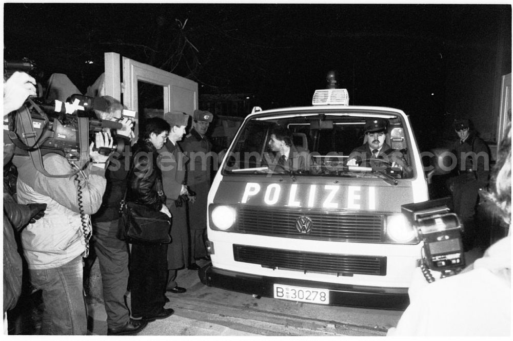 GDR picture archive: Berlin - Öffnungsarbeiten an der Staatsgrenze zum Brandenburger Tor. Polizei-Auto der BRD überquert durch Tor die Grenze von Ost nach West. Pressevertreter und Polizisten stehen drumherum und schauen zu.