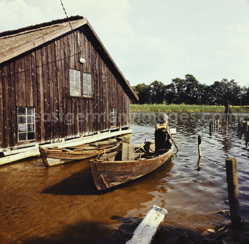 GDR image archive: Kargow - Fisherman at work in his boat on Specker See in Kargow in the state Mecklenburg-Western Pomerania on the territory of the former GDR, German Democratic Republic