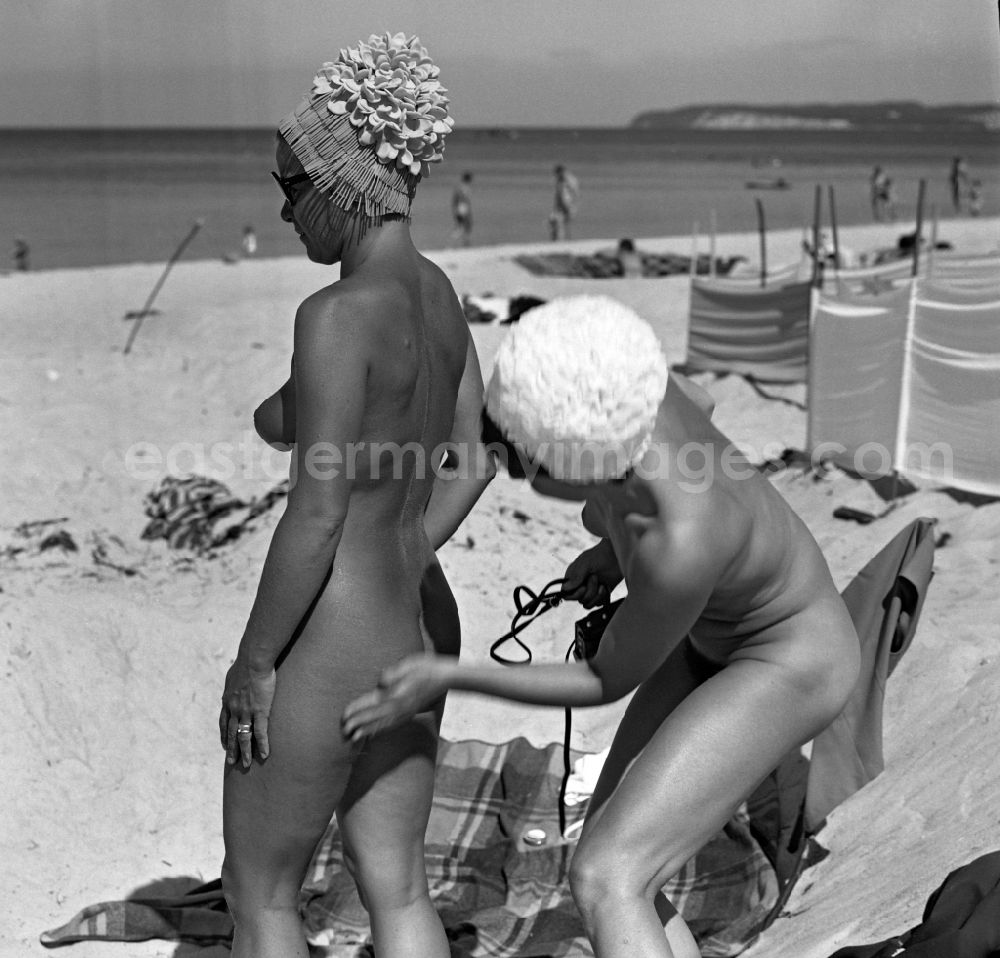 GDR photo archive: Rostock - Women apply sunscreen on the nudist beach on the Baltic Sea in the former capital of the GDR, German Democratic Republic