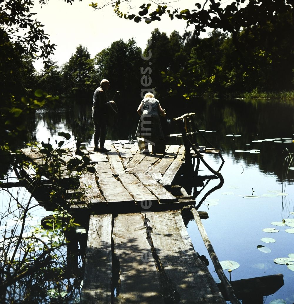 GDR picture archive: Waren (Müritz) - Researcher Ernst Urbahn at work on a bridge at the tone hole in Waren (Mueritz) in the state Mecklenburg-Western Pomerania on the territory of the former GDR, German Democratic Republic