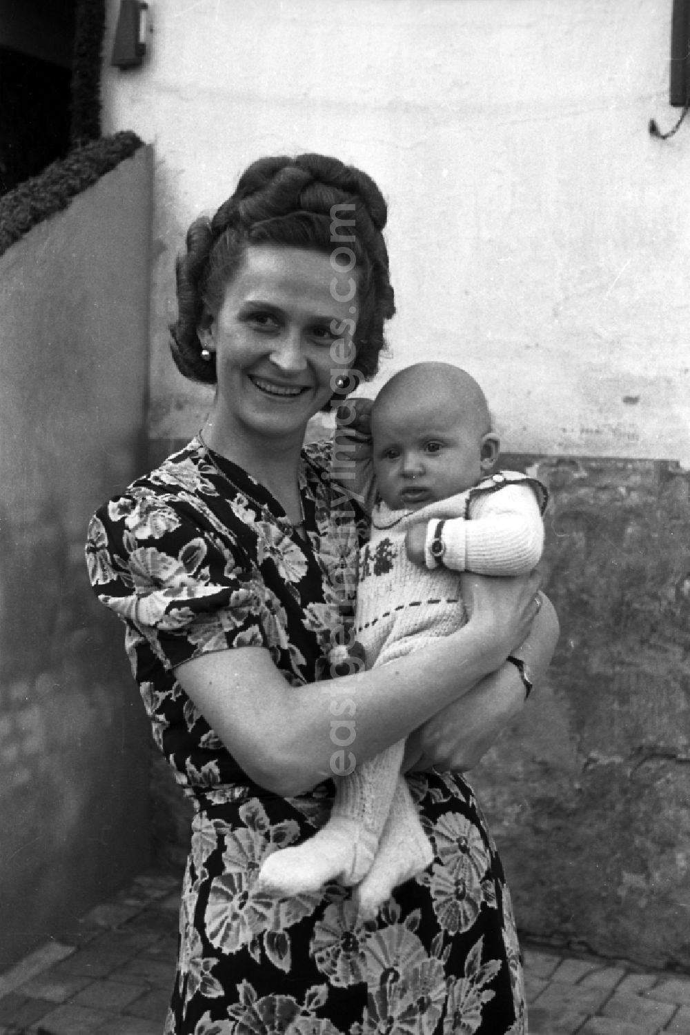 GDR photo archive: Merseburg - A woman holds a baby on the arm in Merseburg in the federal state Saxony-Anhalt in the area of the former GDR, German democratic republic