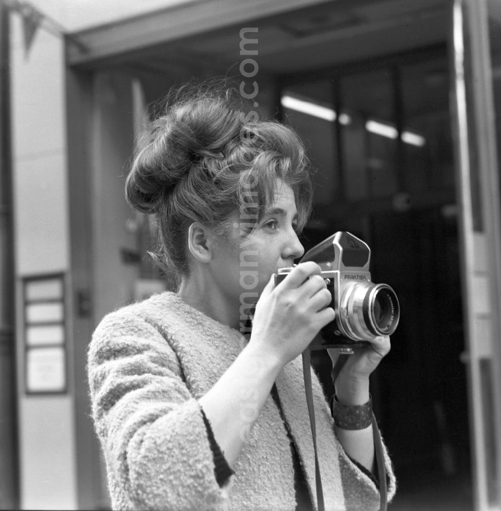 GDR image archive: Magdeburg - A woman in the photograph with a Praktisix in Magdeburg in Saxony - Anhalt. The Praktisix was introduced at Photokina 1956 and produced in its first version from 1957 to 1964