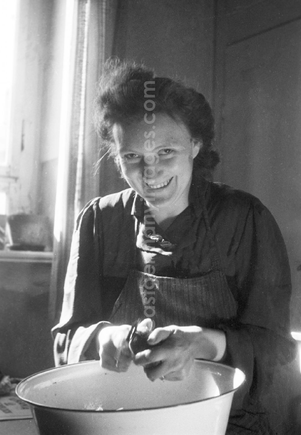 GDR photo archive: Merseburg - Woman with the potato peel in the kitchen in Merseburg in the federal state Saxony-Anhalt in Germany