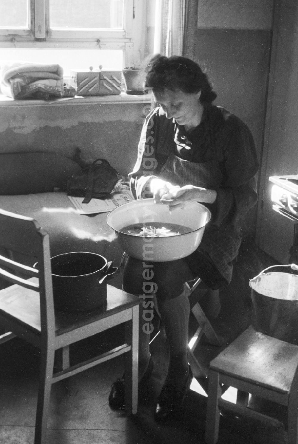 GDR picture archive: Merseburg - Woman with the potato peel in the kitchen in Merseburg in the federal state Saxony-Anhalt in Germany