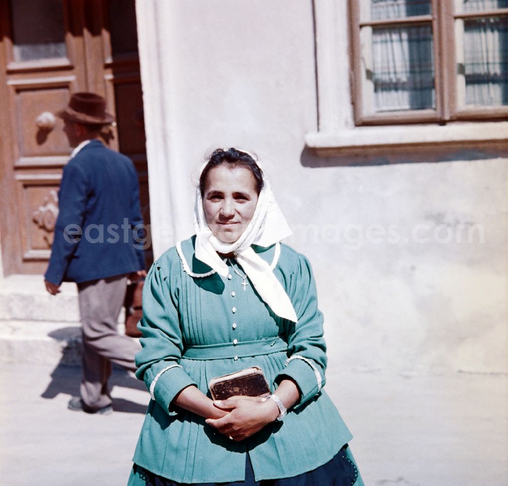 GDR picture archive: Tschechien - A woman is standing with a book in her hands in front of a house in the former CSSR while she is being photographed