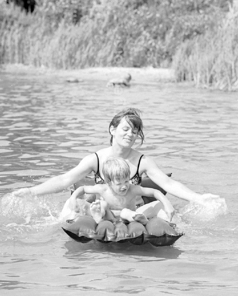 GDR picture archive: Teupitz - Woman with child on an air mattress on the Teupitzer lake in Teupitz in Brandenburg on the territory of the former GDR, German Democratic Republic