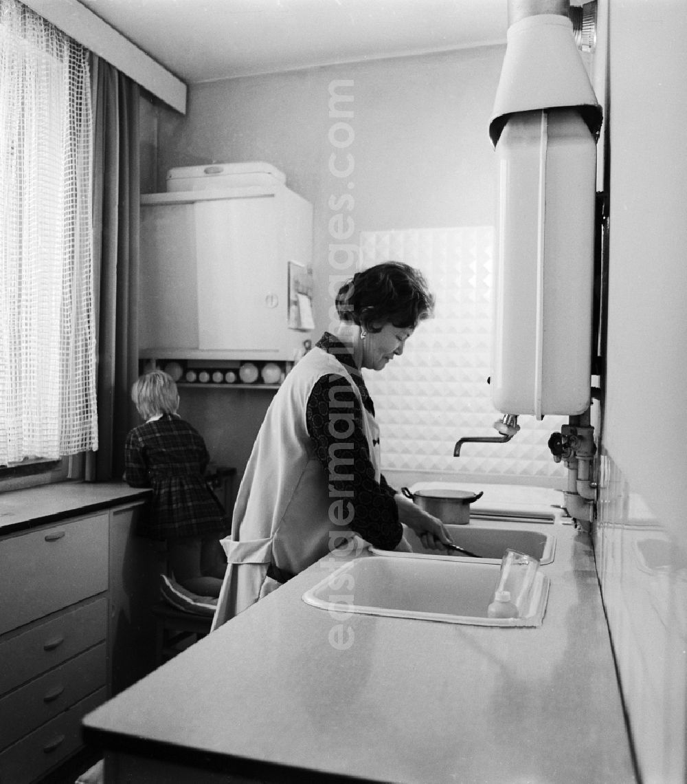 GDR image archive: Berlin - Woman with smock at the wash in the kitchen in Berlin, the former capital of the GDR, German Democratic Republic