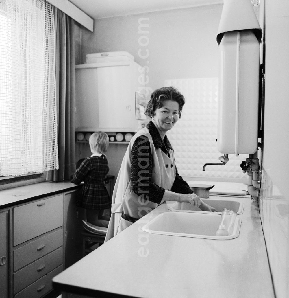 GDR photo archive: Berlin - Woman with smock at the wash in the kitchen in Berlin, the former capital of the GDR, German Democratic Republic
