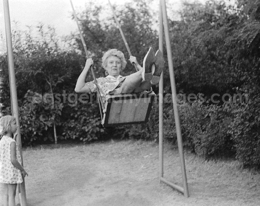 GDR photo archive: Merseburg - A woman swings on a child swing in Merseburg in the federal state Saxony-Anhalt in the area of the former GDR, German democratic republic