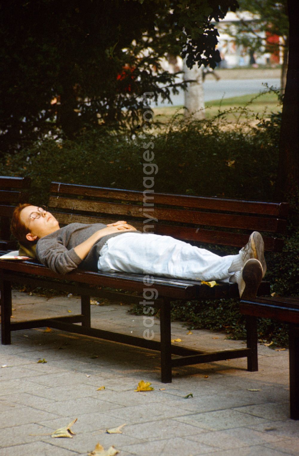 GDR image archive: Berlin - Woman sleeping on a park bench in Berlin-Mitte in the area of the former GDR, German Democratic Republic