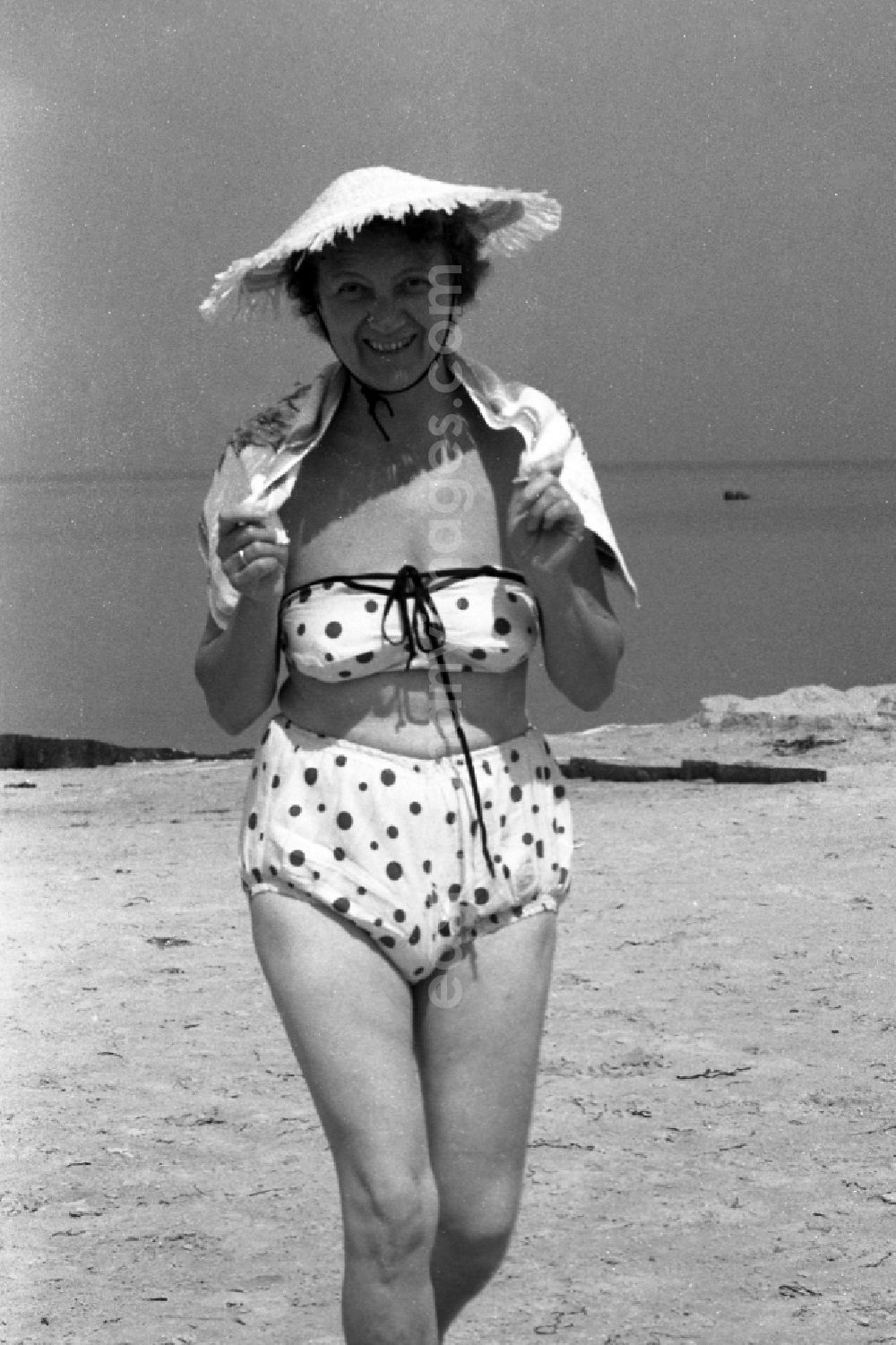 GDR image archive: Heringsdorf - A woman with straw hat and in the bikini on the beach of the Baltic Sea in herring village in the federal state Mecklenburg-West Pomerania in the area of the former GDR, German democratic republic