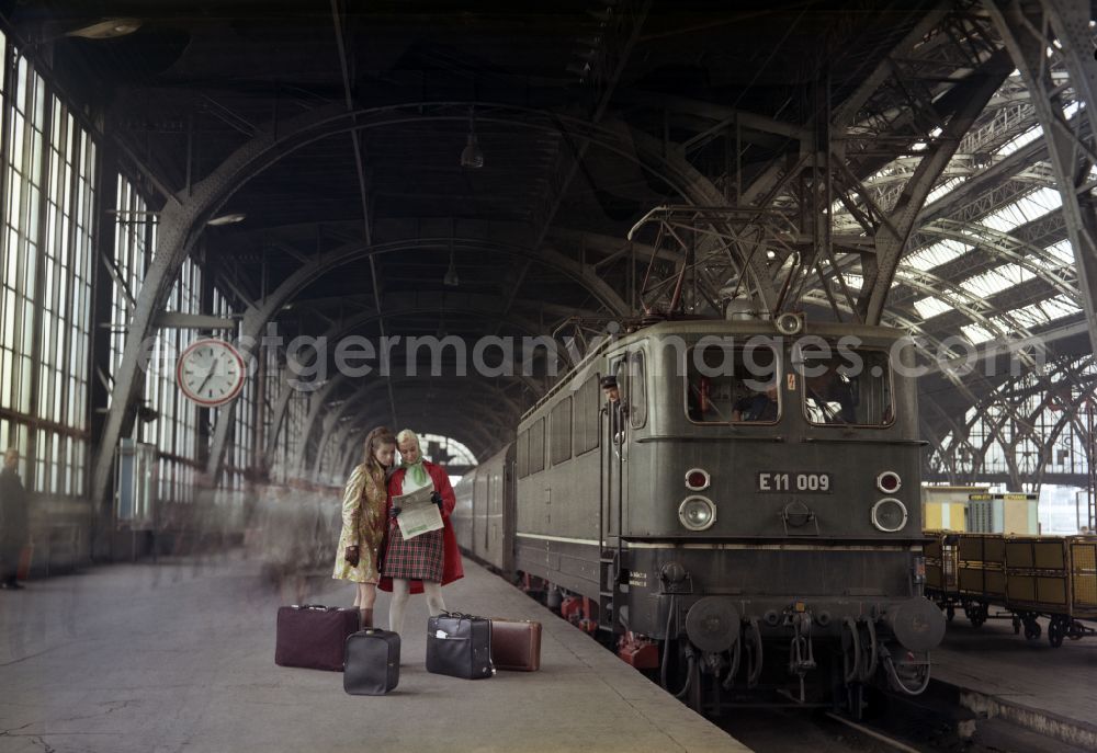 GDR photo archive: Berlin - Women stand on a platform at the Ostbahnhof next to a class E 11 railcar in Berlin in the territory of the former GDR, German Democratic Republic