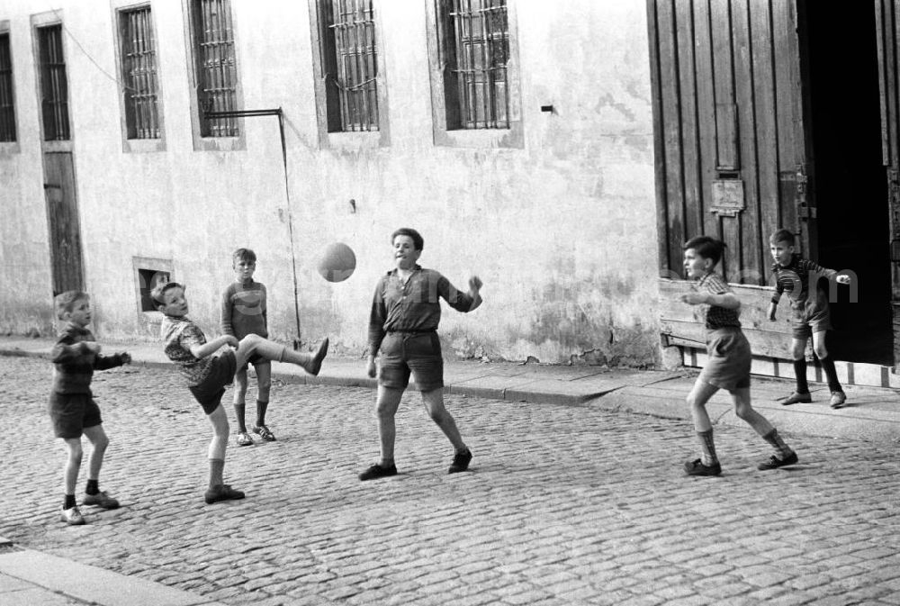 GDR image archive: Freiberg - Jungen spielen Fußball auf einer Straße in Freiberg.