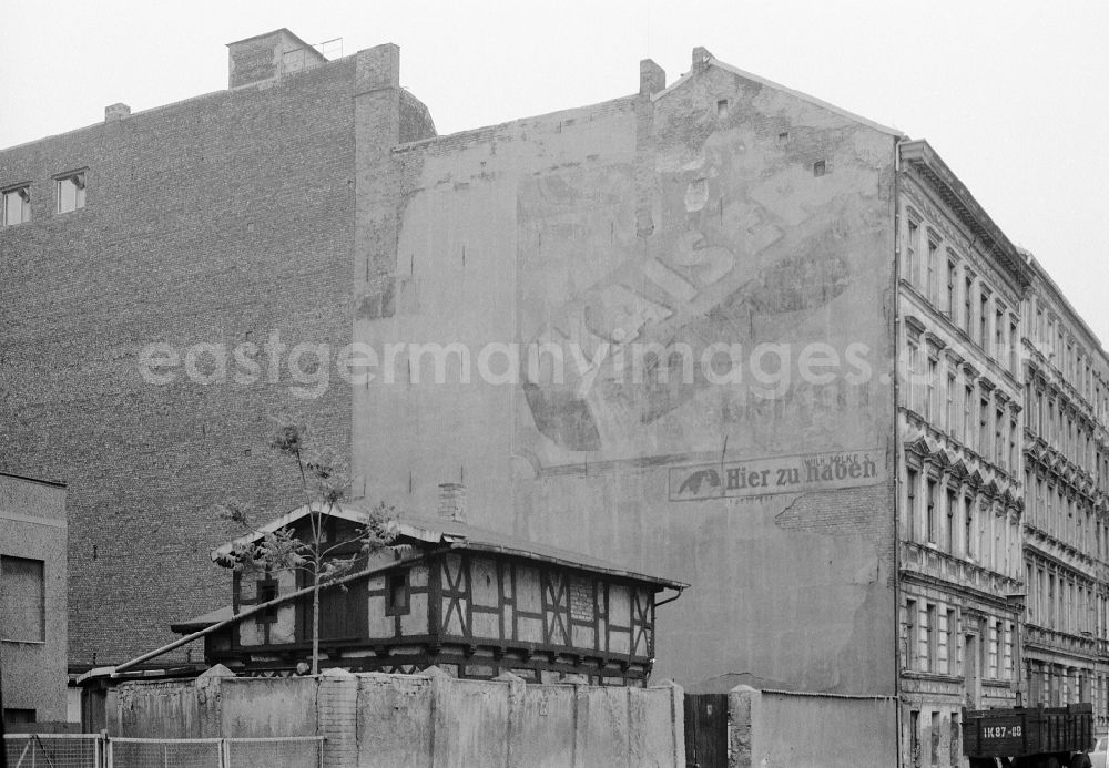 GDR image archive: Berlin - Free-standing gable wall of an old residential building facade in an old apartment building development with Kaiser briquette coal trade advertising on Schwedter Strasse in the Prenzlauer Berg district of Berlin East Berlin in the area of the former GDR, German Democratic Republic