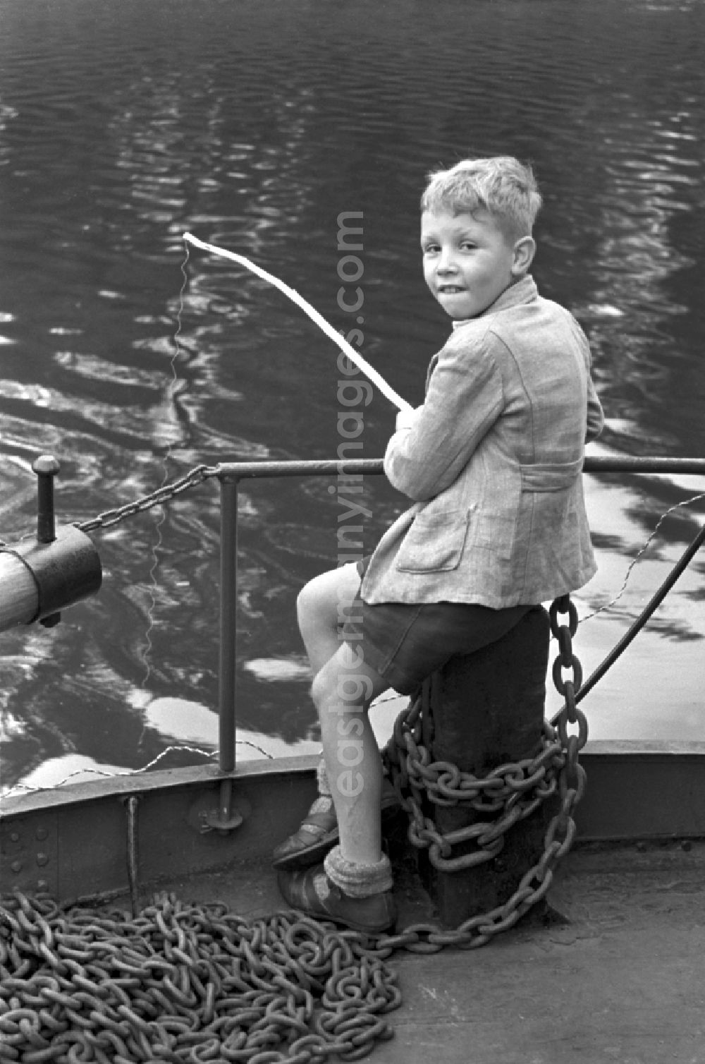 Dresden: Enduring fishing with a hand fishing rodby a little boy on street Terrassenufer in Dresden, Saxony on the territory of the former GDR, German Democratic Republic