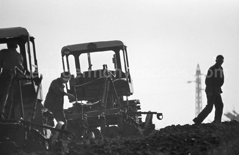 GDR picture archive: Freyburg - Mit Traktoren pflügen Bauern ein Feld in der Nähe von Freyburg, um den Acker für die Aussaat vorzubereiten.