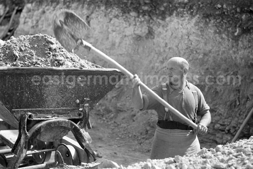 GDR picture archive: Freyburg - In mühsamer Handarbeit wird der Sand- und Kiesabbau im Tagebau östlich von Freyburg betrieben. Von hier aus werden die wichtigen Rohstoffe für den Bau von Häusern, Straßen und Betrieben an die Baulieferanten weitergeleitet.