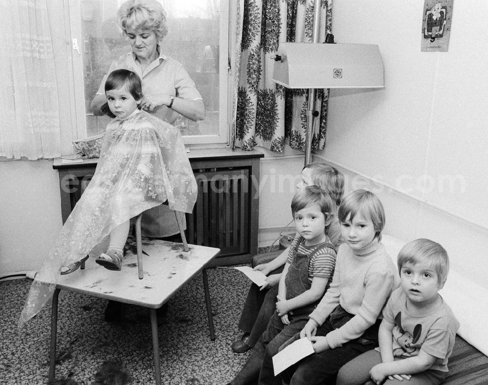 GDR photo archive: Berlin - A hairdresser cuts to the children the hair in the nursery school in Berlin, the former capital of the GDR, German democratic republic