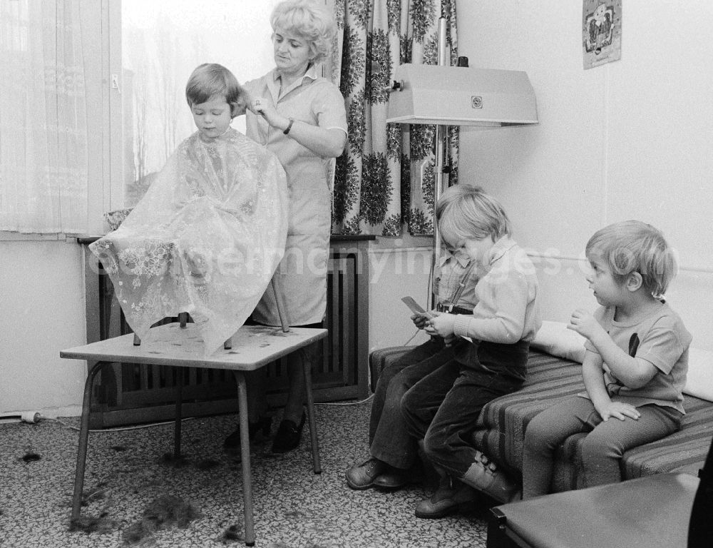 GDR picture archive: Berlin - A hairdresser cuts to the children the hair in the nursery school in Berlin, the former capital of the GDR, German democratic republic